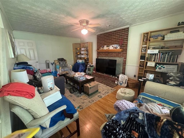 713 Pine Chase Ct, Lawrenceville, GA 30043 - living area featuring a textured ceiling, wood finished floors, a ceiling fan, and a brick fireplace