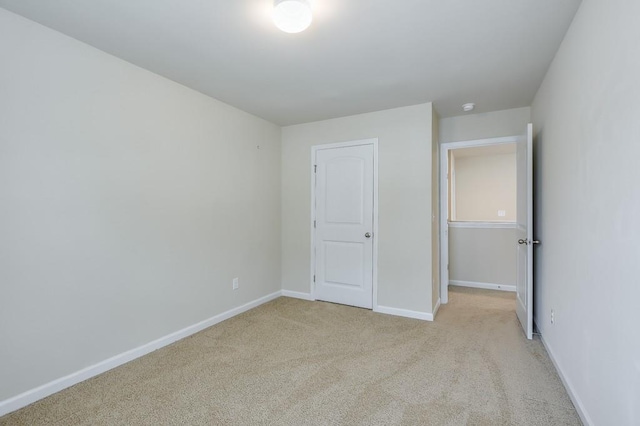 unfurnished bedroom with light carpet and baseboards