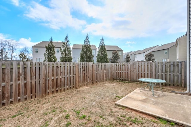 view of yard featuring a residential view, a patio area, and a fenced backyard