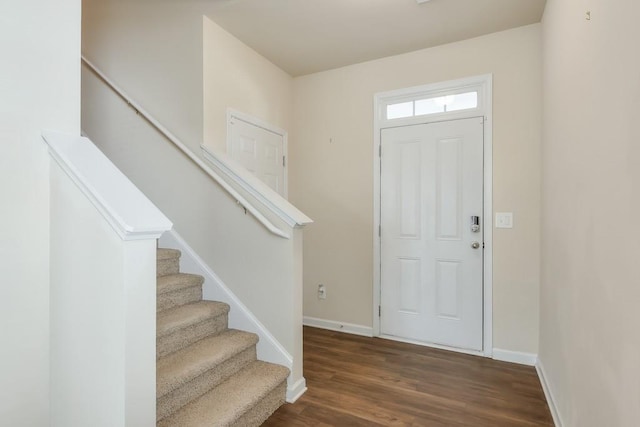 entryway with stairway, dark wood-style flooring, and baseboards