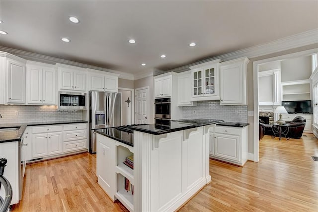 kitchen featuring sink, a breakfast bar area, a center island, appliances with stainless steel finishes, and white cabinets