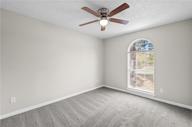 carpeted spare room with a textured ceiling, baseboards, and ceiling fan