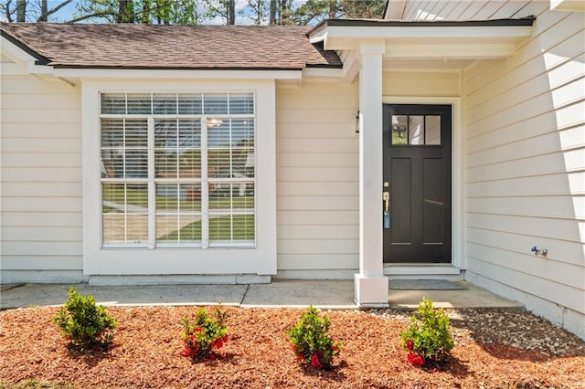 entrance to property with roof with shingles