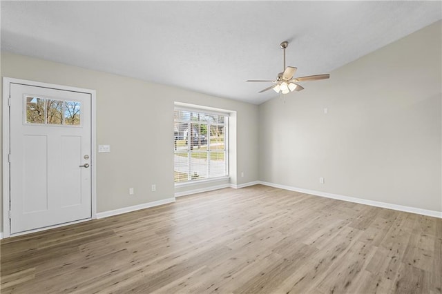 entryway with baseboards, light wood-type flooring, ceiling fan, and vaulted ceiling