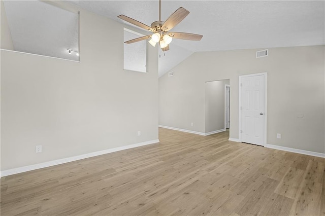 unfurnished room with light wood-style flooring, visible vents, baseboards, a ceiling fan, and vaulted ceiling