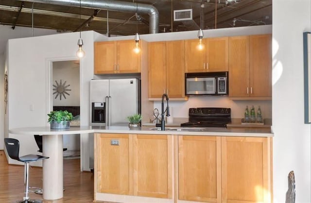 kitchen with stainless steel appliances, light countertops, visible vents, and a sink