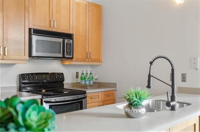 kitchen with light countertops, stainless steel microwave, a sink, and range with electric stovetop