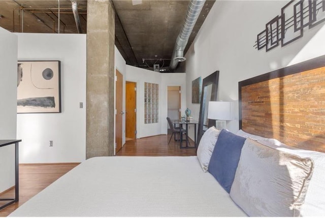 bedroom featuring a high ceiling and wood finished floors