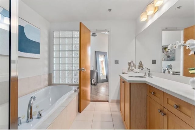 full bath with a jetted tub, vanity, and tile patterned floors