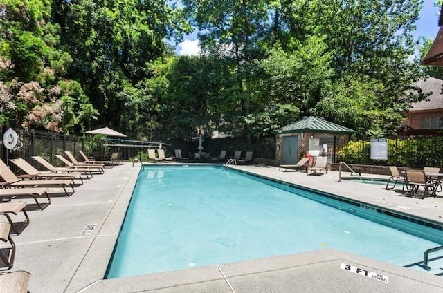 pool with fence and a patio