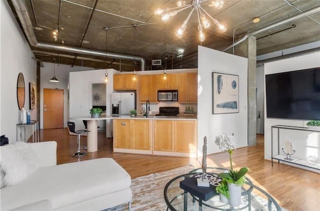 living room with visible vents, a towering ceiling, and light wood-style floors