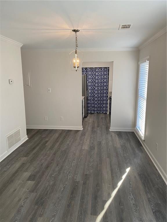 unfurnished dining area featuring ornamental molding, dark wood-type flooring, and a chandelier