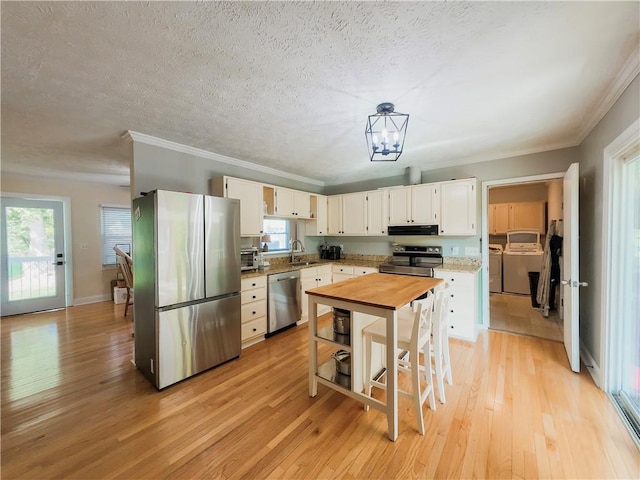 3905 Hunt Dr SE, Gainesville, GA 30507 - kitchen with appliances with stainless steel finishes, light wood-style floors, healthy amount of natural light, crown molding, and white cabinetry
