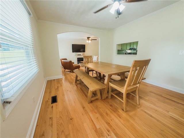 3905 Hunt Dr SE, Gainesville, GA 30507 - dining room featuring ceiling fan, arched walkways, light wood-type flooring, and ornamental molding