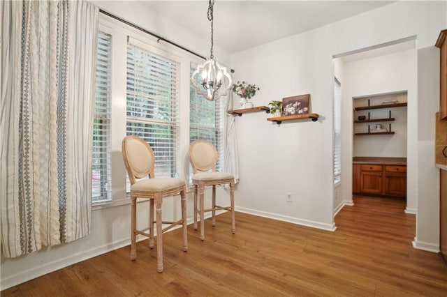 sitting room featuring a wealth of natural light, a chandelier, light wood-style floors, and baseboards