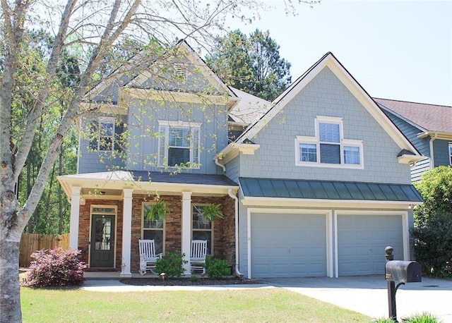 craftsman-style house with covered porch, stone siding, fence, a garage, and concrete driveway