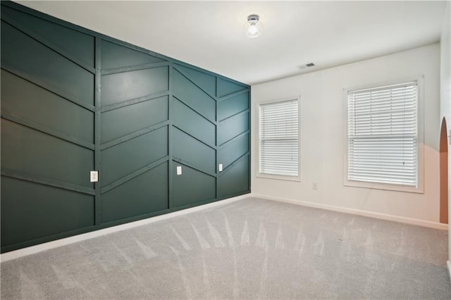 spare room with visible vents, baseboards, and carpet floors