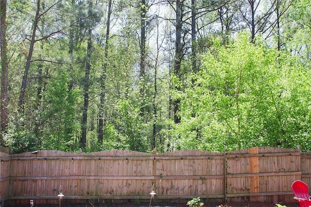 view of yard featuring a view of trees and fence