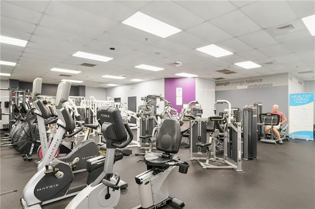 workout area with visible vents and a paneled ceiling