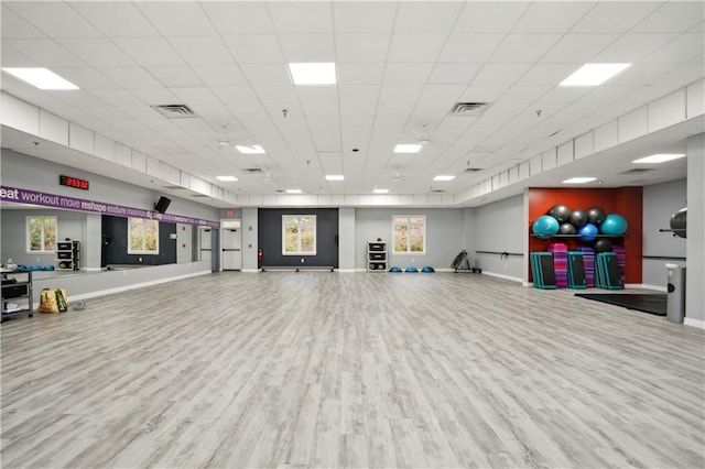 workout room with visible vents, baseboards, a paneled ceiling, and wood finished floors