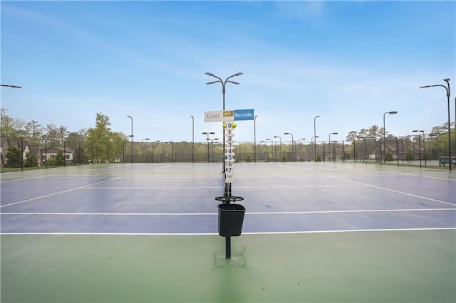 view of tennis court featuring community basketball court and fence