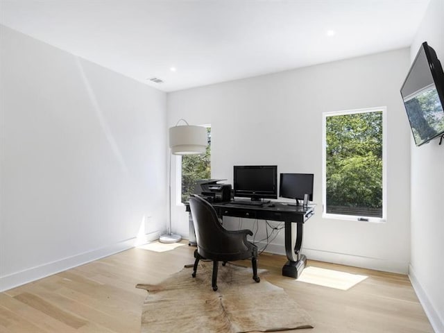 office space with light wood-type flooring and a healthy amount of sunlight