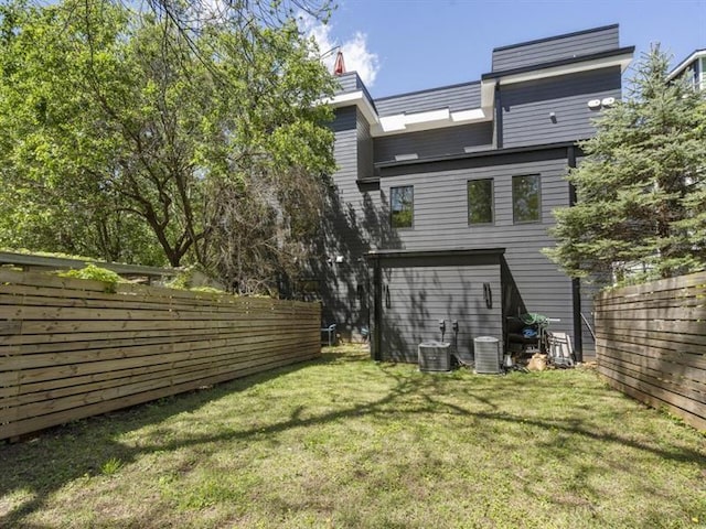 rear view of house featuring a yard and central AC unit