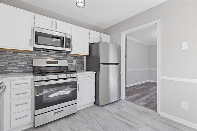 kitchen with white cabinetry, appliances with stainless steel finishes, tasteful backsplash, and baseboards