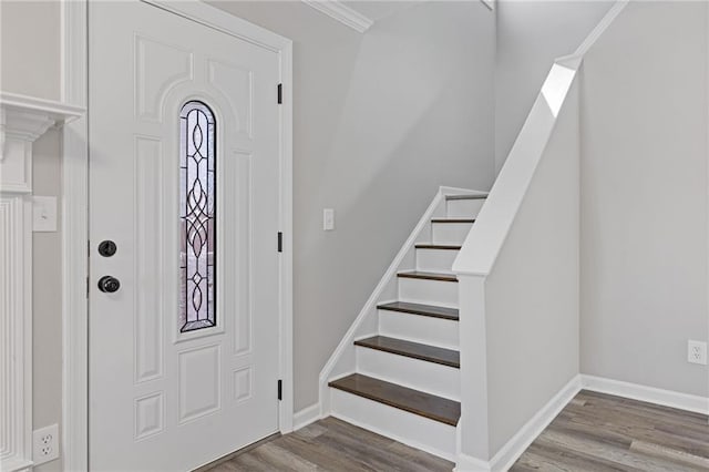 entryway featuring crown molding, stairway, wood finished floors, and baseboards