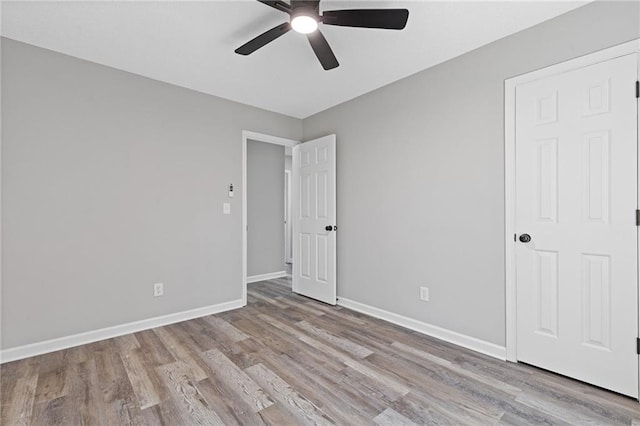 unfurnished room featuring a ceiling fan, baseboards, and wood finished floors