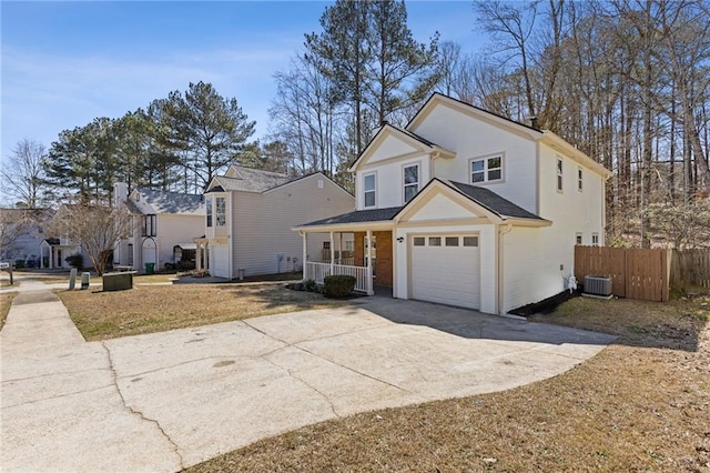 traditional-style house featuring driveway, an attached garage, fence, a porch, and central AC