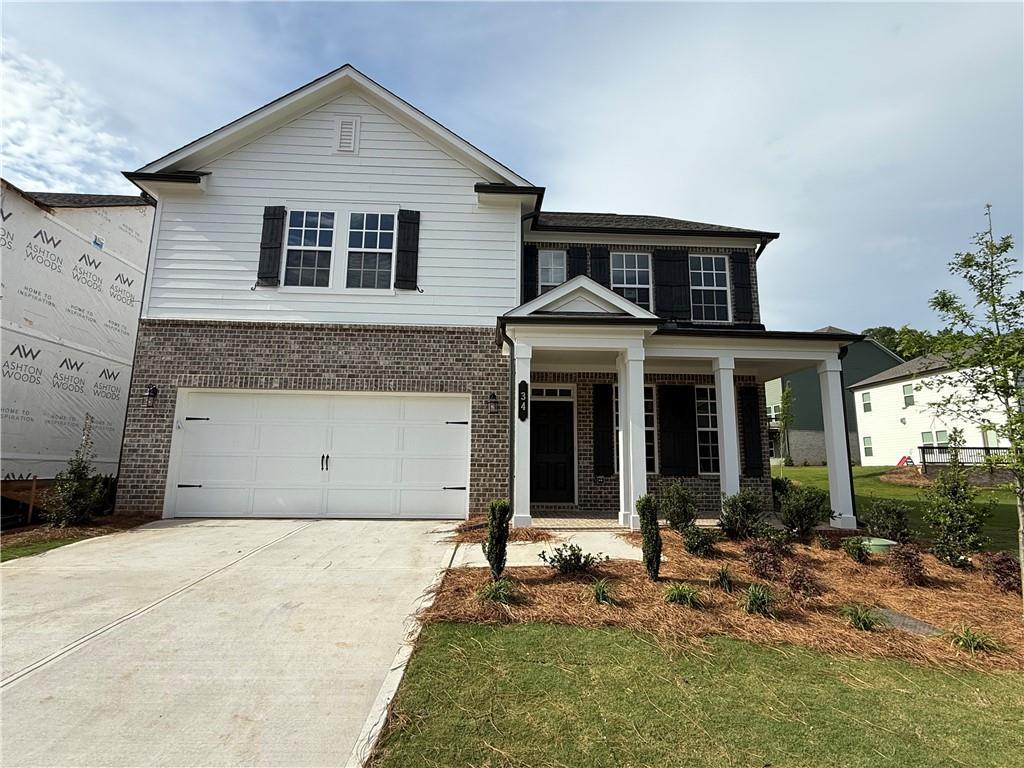view of front facade with brick siding, an attached garage, and concrete driveway