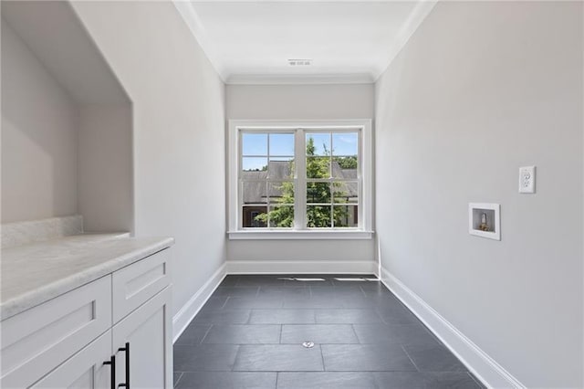 interior space featuring cabinets, washer hookup, and ornamental molding