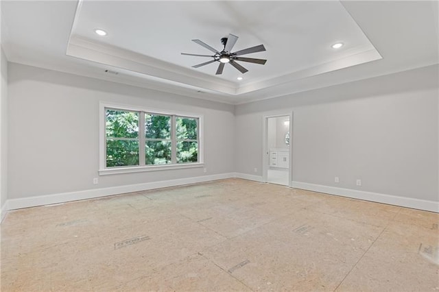 spare room with ceiling fan, ornamental molding, and a tray ceiling