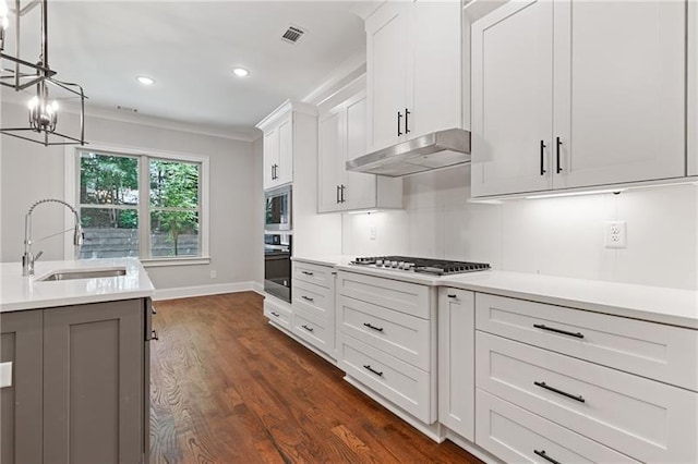 kitchen with white cabinetry, appliances with stainless steel finishes, sink, and pendant lighting