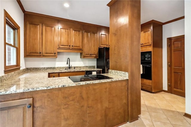 kitchen featuring light stone counters, black appliances, and light tile patterned floors