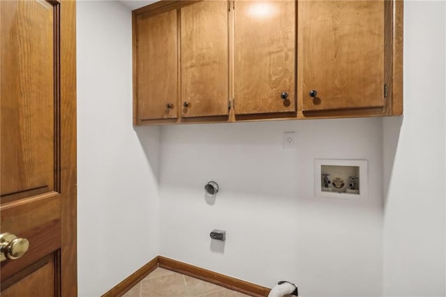 laundry area featuring light tile patterned flooring, hookup for a washing machine, and cabinets