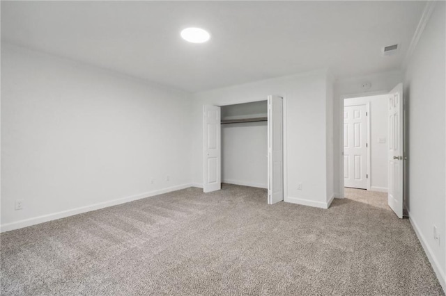 unfurnished bedroom featuring crown molding, a closet, and carpet flooring