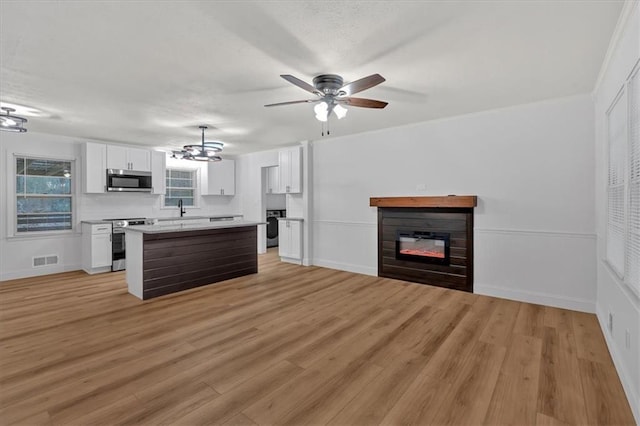 kitchen featuring white cabinetry, washer / clothes dryer, a center island, and appliances with stainless steel finishes