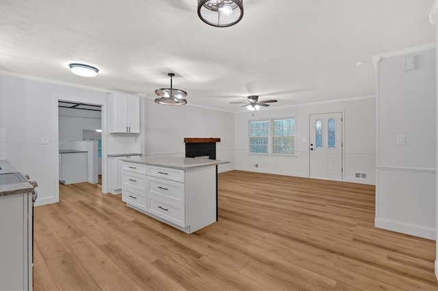 kitchen with white cabinetry, a center island, hanging light fixtures, and light wood-type flooring