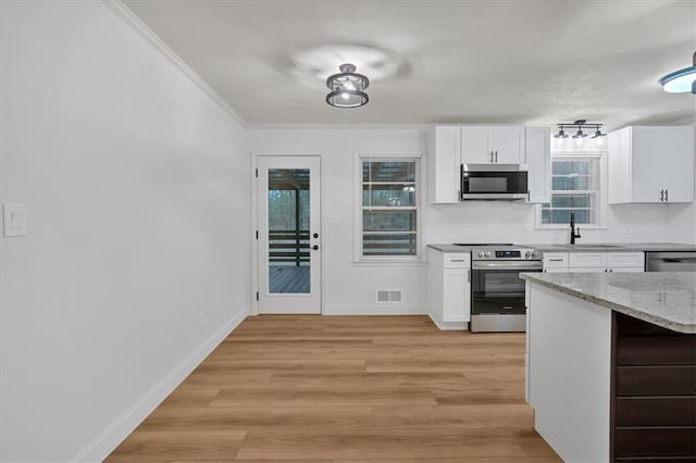 kitchen with decorative backsplash, light hardwood / wood-style flooring, stainless steel appliances, and white cabinets