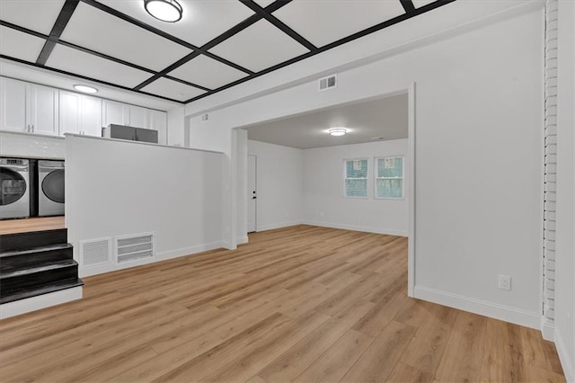 basement featuring separate washer and dryer and light hardwood / wood-style floors