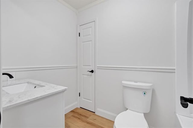 bathroom with crown molding, vanity, toilet, and hardwood / wood-style floors