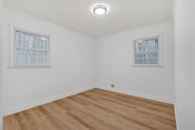 spare room featuring ornamental molding and hardwood / wood-style floors