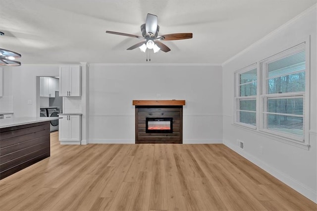 unfurnished living room featuring crown molding, ceiling fan, washer / clothes dryer, and light hardwood / wood-style floors