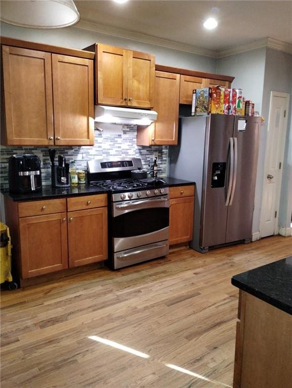 kitchen with crown molding, light hardwood / wood-style floors, decorative backsplash, and appliances with stainless steel finishes