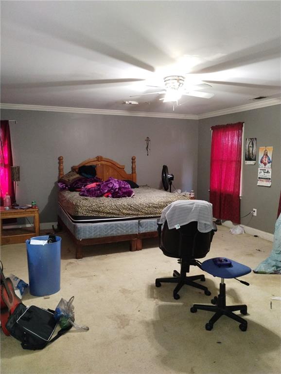 carpeted bedroom featuring ceiling fan and ornamental molding