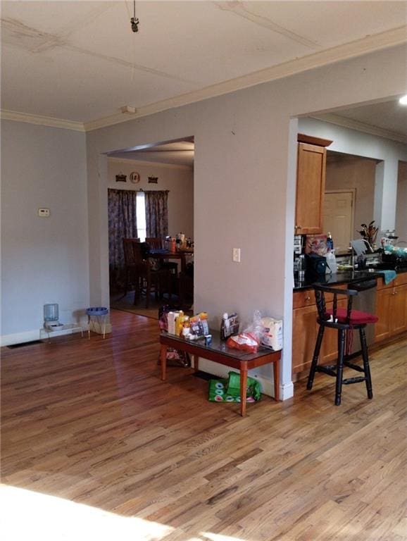 interior space with light hardwood / wood-style flooring and ornamental molding