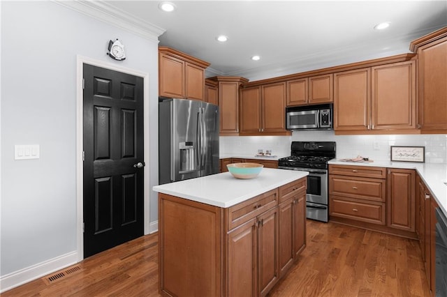 kitchen with a kitchen island, visible vents, crown molding, tasteful backsplash, and stainless steel appliances