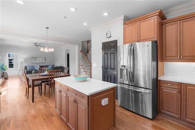 kitchen with crown molding, stainless steel fridge, light wood-style flooring, recessed lighting, and open floor plan